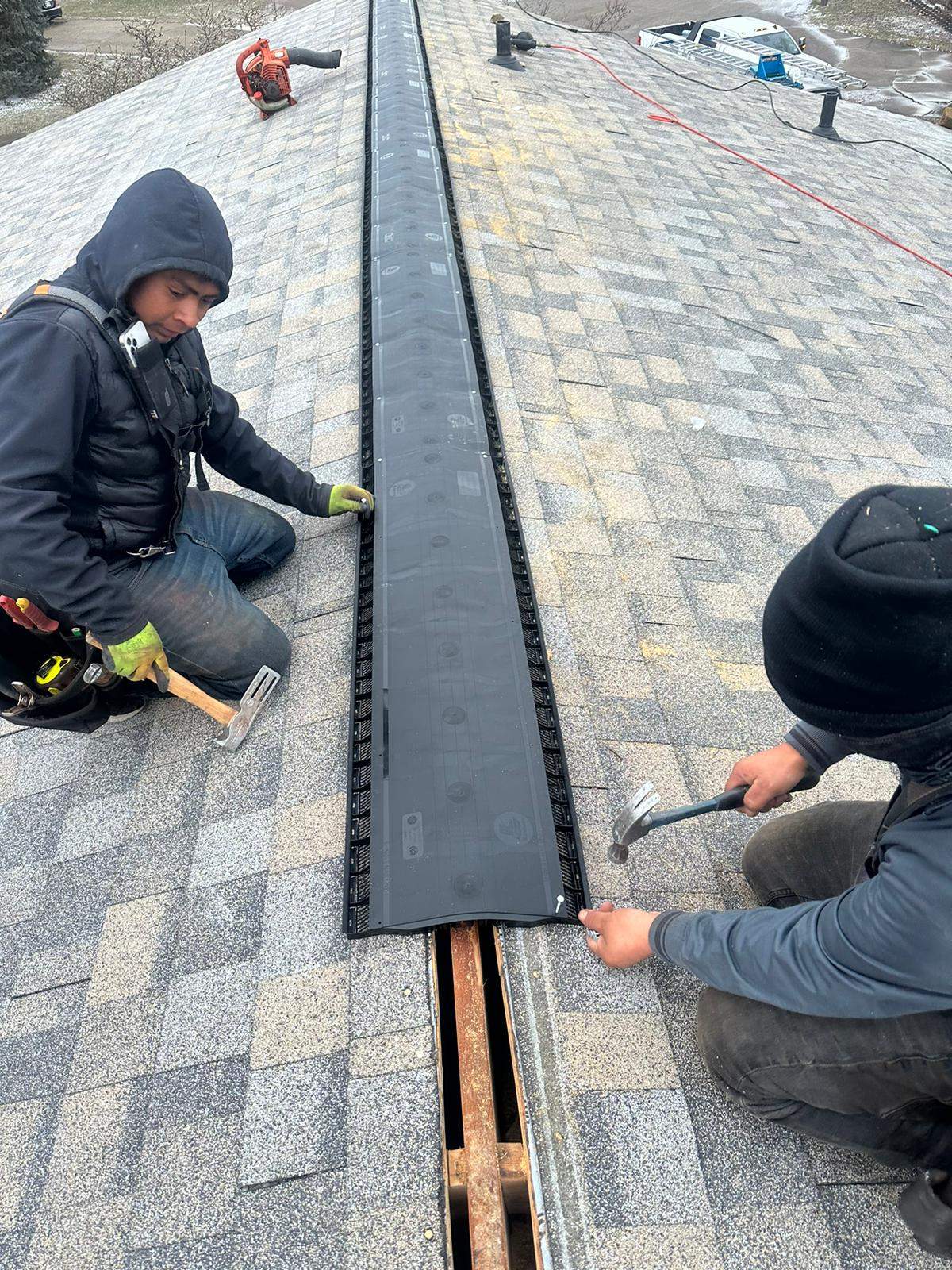 Ridge vent installation on residential asphalt shingle roof for proper attic ventilation