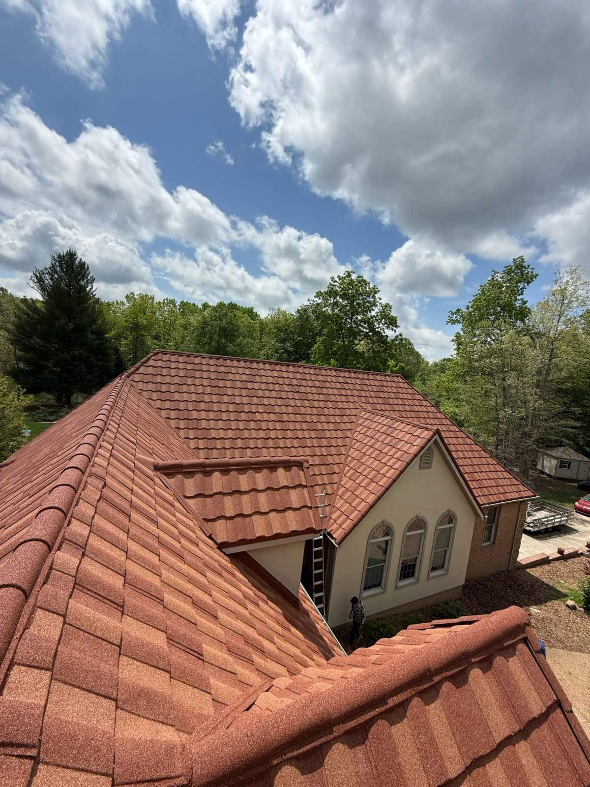 Terracotta stone coated steel tile profile on residential home with arched windows