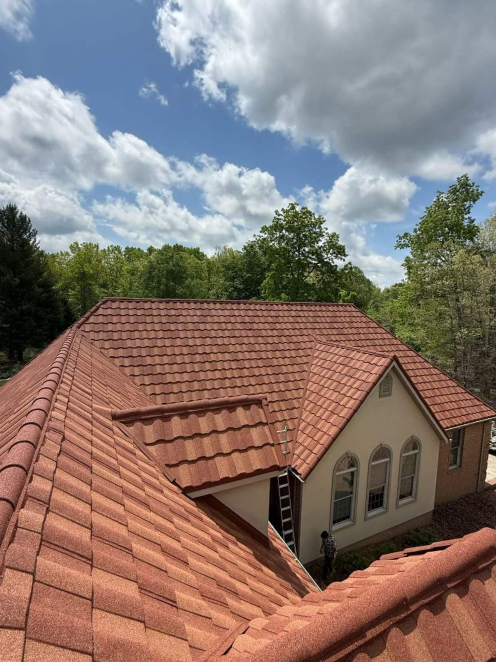 Terracotta stone-coated metal tile roof with ridge caps on stucco home